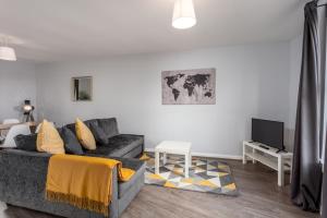 a living room with a couch and a tv at Ayr Retreat - Donnini Apartments in Ayr