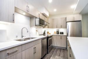 a kitchen with wooden cabinets and stainless steel appliances at Revelstoke Retreat by Revelstoke Vacations in Revelstoke