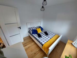 1 cama pequeña con 2 almohadas en una habitación en Domek przy plaży, en Mikołajki