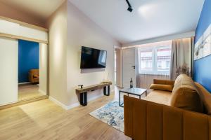a living room with a couch and a tv at Apartamenty Greenpoint Dźwirzyno in Dźwirzyno