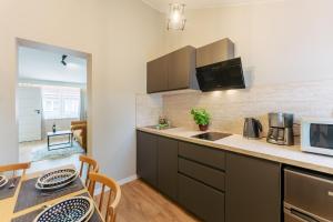 a kitchen with a counter top and a table with chairs at Apartamenty Greenpoint Dźwirzyno in Dźwirzyno