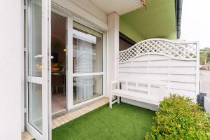 a front porch with a bench and green grass at Apartamenty Greenpoint Dźwirzyno in Dźwirzyno