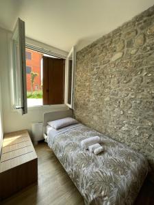 a bedroom with a bed and a stone wall at LOCANDA LA CAMPAGNOLA orari check in dalle 1130 alle 1530 e dalle 1830 alle 2330 in Vignola +23 photos