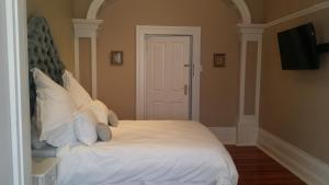 a bedroom with a bed with white sheets and pillows at Park Place Boutique Guesthouse in East London