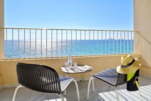 a balcony with a table and chairs and the ocean at Hotel Stella Di Mare in Ajaccio