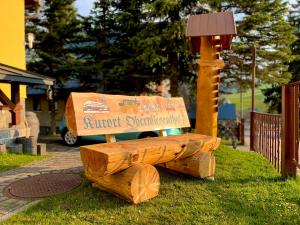 a wooden bench sitting in the grass next to a bird sanctuary at Ferienwohnung-direkt-am-skihang in Kurort Oberwiesenthal