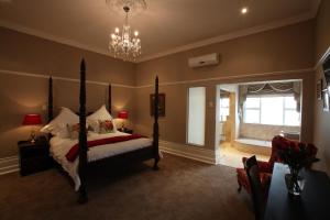 a bedroom with a bed and a chandelier at Park Place Boutique Guesthouse in East London