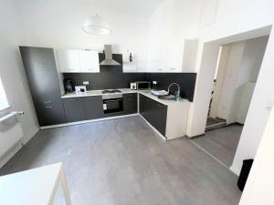 een keuken met grijze en witte kasten en een wastafel bij Wohnung in Düren Stadtmitte in Düren - Eifel