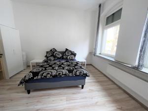 a bedroom with a bed with a black and white comforter at Wohnung in Düren Stadtmitte in Düren - Eifel