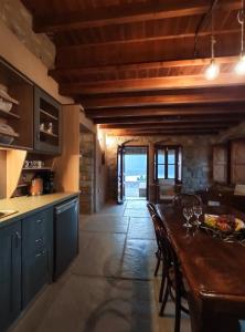 una cocina con una mesa de madera larga y sillas en Grande Grotta House, en Myrties 42 fotos más