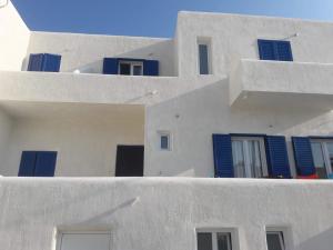 a group of white buildings with blue windows at Ios Fantasy in Ios Chora