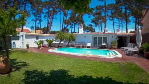 een achtertuin met een zwembad en een huis bij Guest House Ruceel Aroeira in Almada