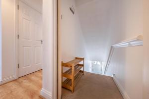 2BR Spacious Apartment Stansted Airport & Bishops Stortford Town في بيشوبس ستورتفورد: غرفة بها باب وكرسي خشبي