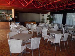 a room filled with tables and white chairs at Sol Victoria Marina in Salvador