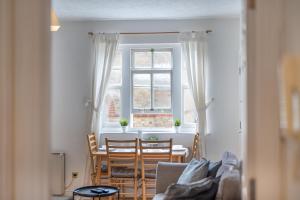 2BR Spacious Apartment Stansted Airport & Bishops Stortford Town في بيشوبس ستورتفورد: غرفة معيشة بها طاولة وكراسي ونافذة