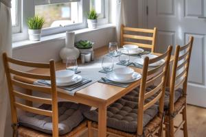 a dining room table with chairs and a wooden table and chairsuggest at Stansted Airport & Bishops Stortford Town Centre Professional Apartment in Bishops Stortford