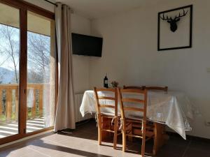 a dining room with a table and chairs and a window at Appartement 2 Chambres au calme in Les Angles