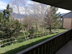 a balcony with a view of a fence and trees at Appartement 2 Chambres au calme in Les Angles