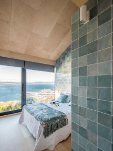 1 dormitorio con cama y ventana grande en MIRAFLORES Alojamiento Turístico, en Muros