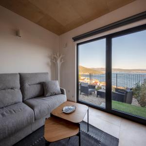 sala de estar con sofá y ventana grande en MIRAFLORES Alojamiento Turístico en Muros