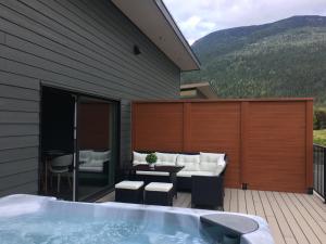 a hot tub on a deck with a table and chairs at The Revy Den by Revelstoke Vacations in Revelstoke