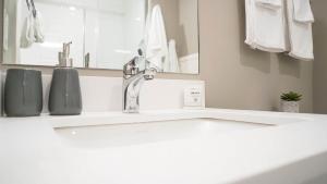 a bathroom with a white sink and a mirror at The Revy Den by Revelstoke Vacations in Revelstoke +19 photos