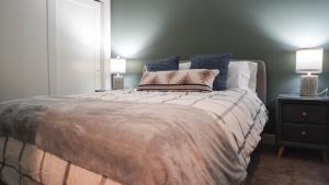 a bedroom with a large bed with two lamps at The Revy Den by Revelstoke Vacations in Revelstoke