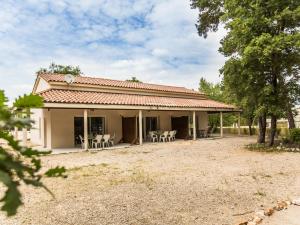 une maison avec des tables et des chaises dans une cour dans l'établissement Villa La Lauze, à Labastide-de-Virac