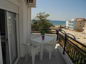 a white table and chairs on a balcony with the beach at Villa Chrissa in Limenaria