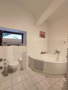 ein weißes Bad mit einer Badewanne und einem WC in der Unterkunft Ferienwohnung am Rabenauer Grund in Freital