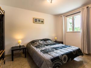 a bedroom with a bed with two tables and a window at Villa La Lauze in Labastide-de-Virac