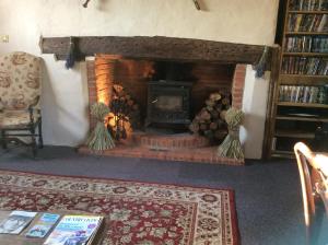 a living room with a brick fireplace with a fire place at Valley Farmhouse B&B in Southwold