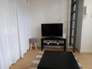 a living room with a tv and a table at Studio avec terrasse en résidence calme à Dijon. in Dijon