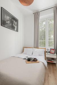 Un dormitorio con una cama blanca y una bandeja. en oompH Warsaw Nowy Swiat Apartment, en Varsovia