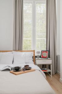 a white bed with a tray of food on it at oompH Warsaw Nowy Swiat Apartment in Warsaw