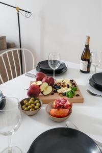 a table with a plate of food and wine glasses at oompH Warsaw Nowy Swiat Apartment in Warsaw