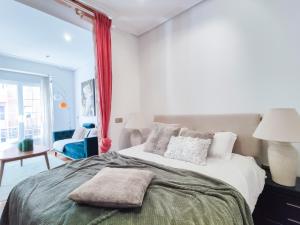 - une chambre blanche avec un grand lit et des oreillers dans l'établissement Chueca Boutique, à Madrid