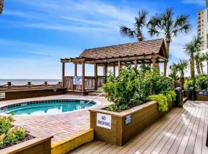 a swimming pool with a gazebo next to the beach at 0308 Waters Edge Resort condo in Myrtle Beach