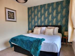 a bedroom with a bed with a blue blanket on it at 3 Bedroom Aprtmt at Sensational Stay Serviced Accommodation Aberdeen- Froghall Avenue in Aberdeen