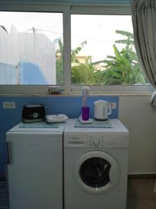 een wasmachine en droger in een kamer met een raam bij Valantas Garden Suite in Lardos
