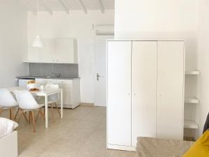 波多河麗的住宿－Palm Suite Yellow，白色的厨房配有桌子和白色橱柜
