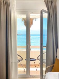 een slaapkamer met uitzicht op de oceaan bij Palm Suite Yellow in Porto Cheli