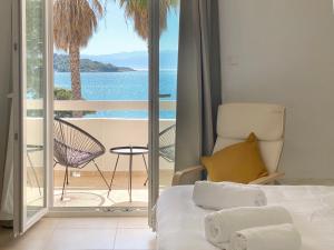 um quarto com uma cama e vista para o oceano em Palm Suite Yellow em Porto Heli