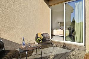 a patio with two chairs and a table with a bottle of water at Hotel Stella Di Mare in Ajaccio