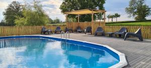 a swimming pool with chairs and a gazebo at Le Petit Moulin in Saint-Hilaire
