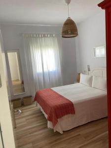 a bedroom with a bed with a red blanket and a mirror at Casa Angy 3 in Zahora