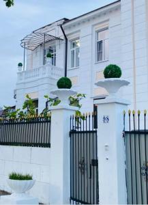 una casa blanca con una puerta y una valla con plantas en Бутик-отель Белый Дом Балерины, en Sukhum