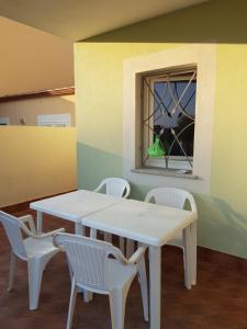 ヴァッレドーリアにあるvilla "LA PINA"の窓付きの客室で、白いテーブルと椅子が備わります。