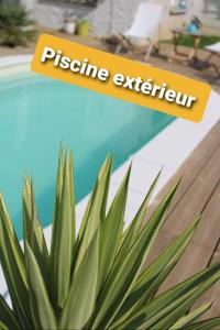 een teken dat prestige expert naast een plant leest bij "Chez Lyly et Juju" Piscine&Calme 3Chambres in Angers