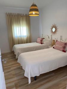 a hotel room with two beds and a chandelier at Casa Angy 3 in Zahora